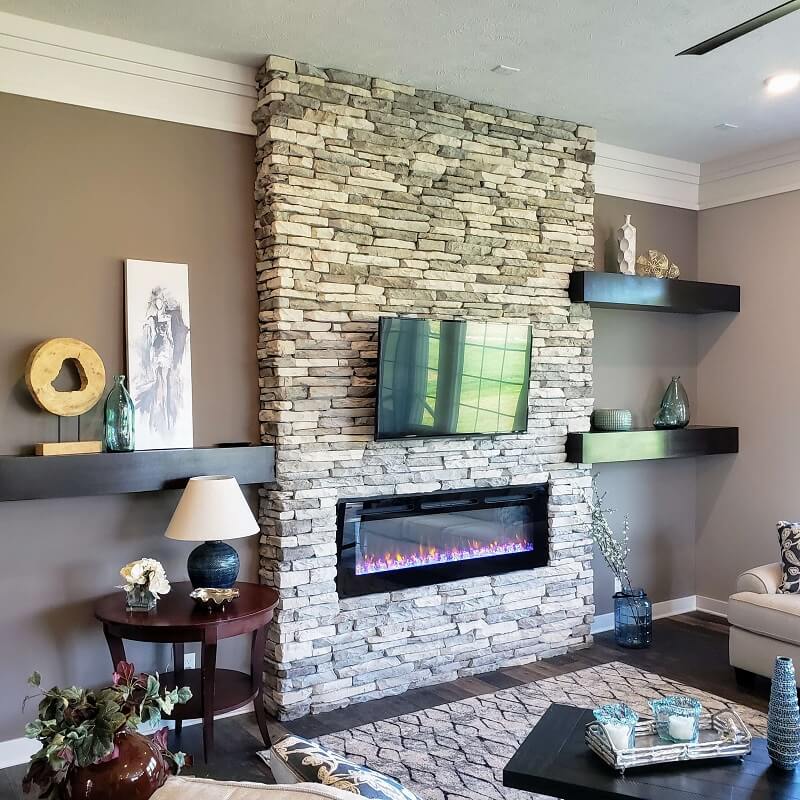 Living room with stone fireplace and floating shelves